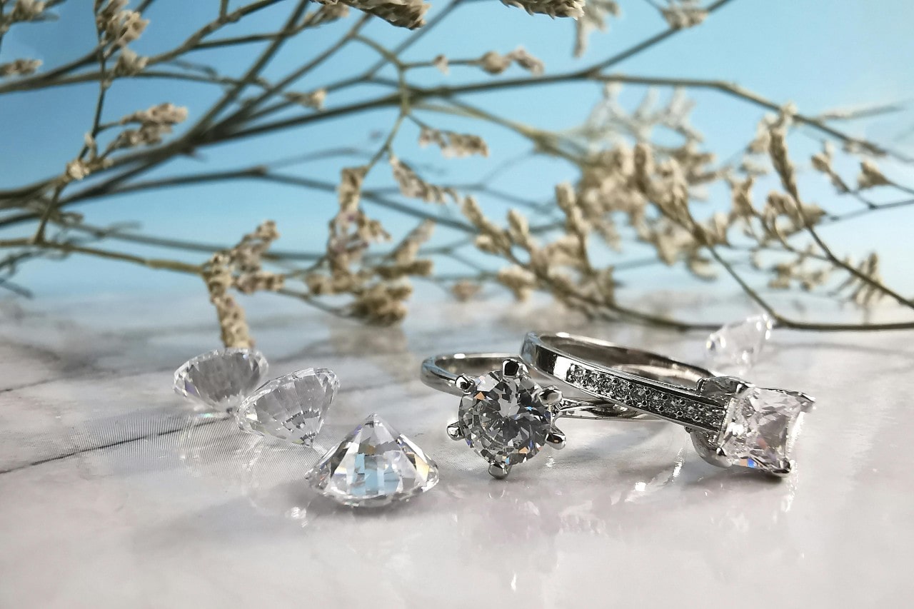 two diamond rings surrounded by loose diamonds and flowering branches