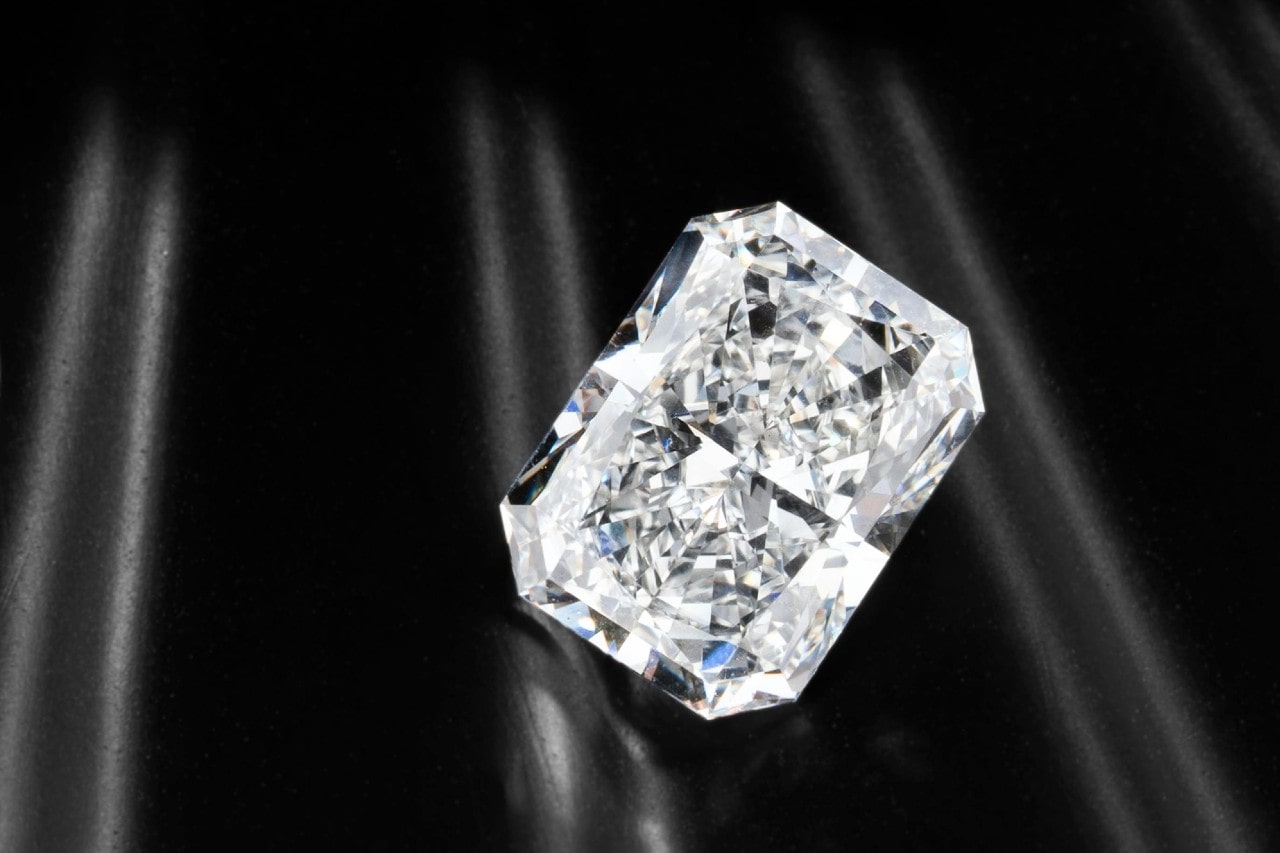 a radiant cut diamond on a reflective black surface