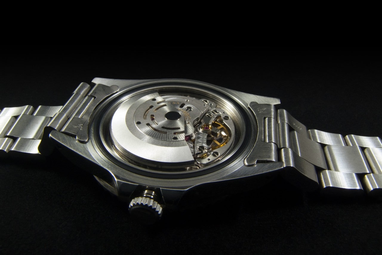 A close-up of the back of a luxury watch, meticulously constructed in stainless steel.